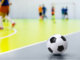 Children playing futsal indoors