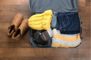 Open suitcase packed for ski holiday